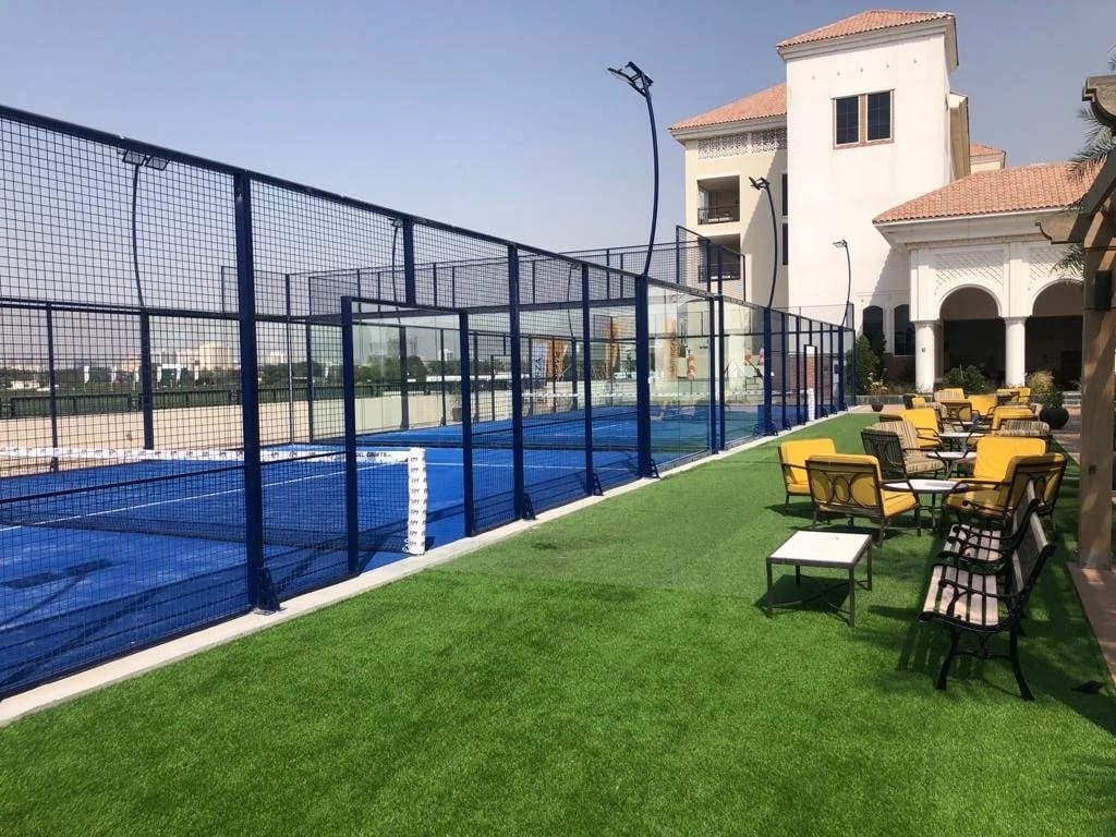 The outdoor glass padel court at Al Habtoor Polo Club, empty.